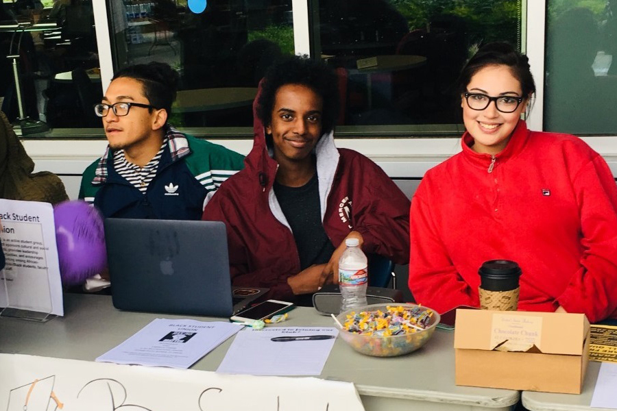 Students sitting at the Black Student Union table at an events and activities fair.