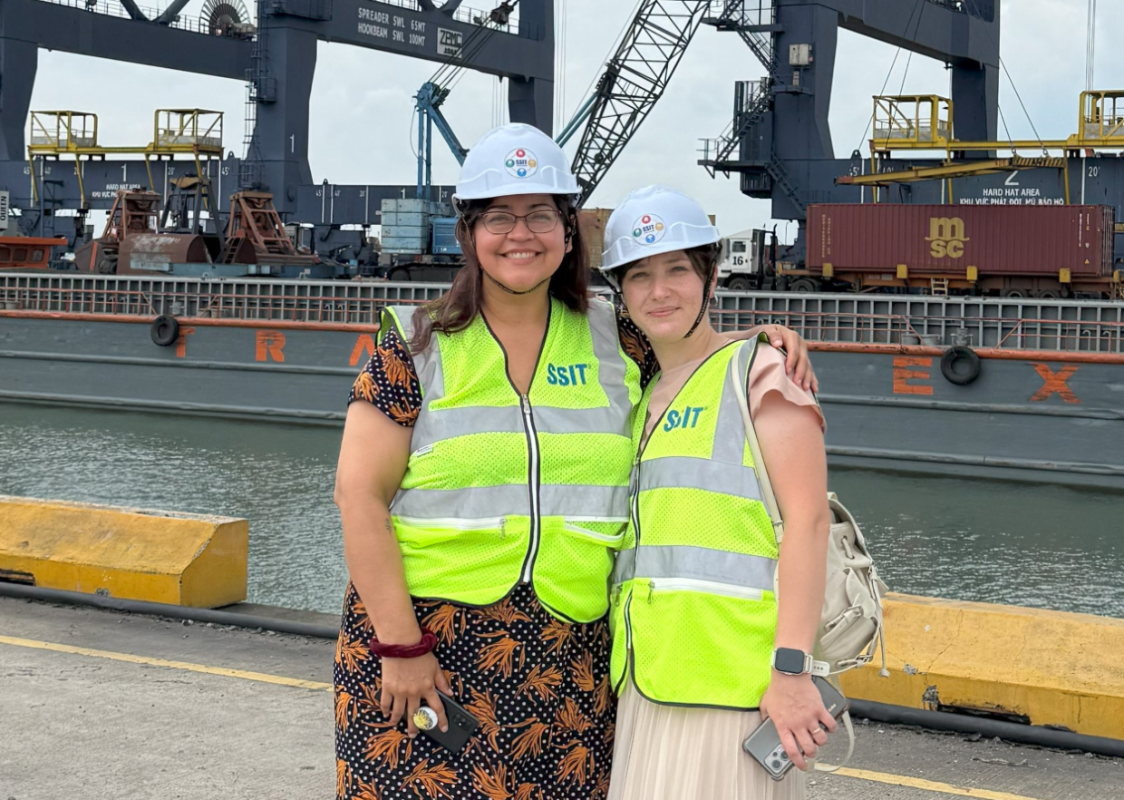 two females in Vietnam wearing yellow safety vests and hard hats 