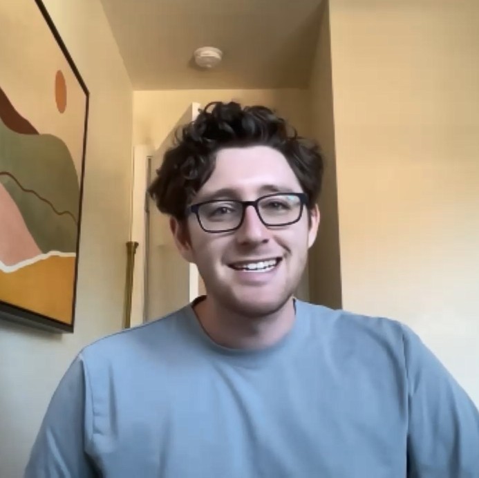 Lenny Brown, male wearing a blue shirt with glasses smiling 