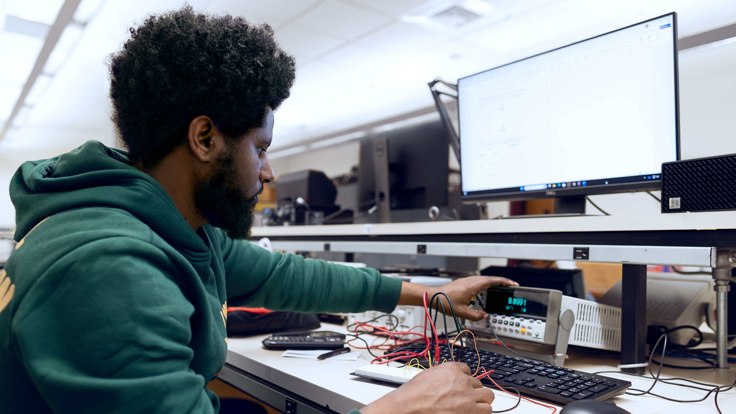 male studying in front of mother boards for electronics