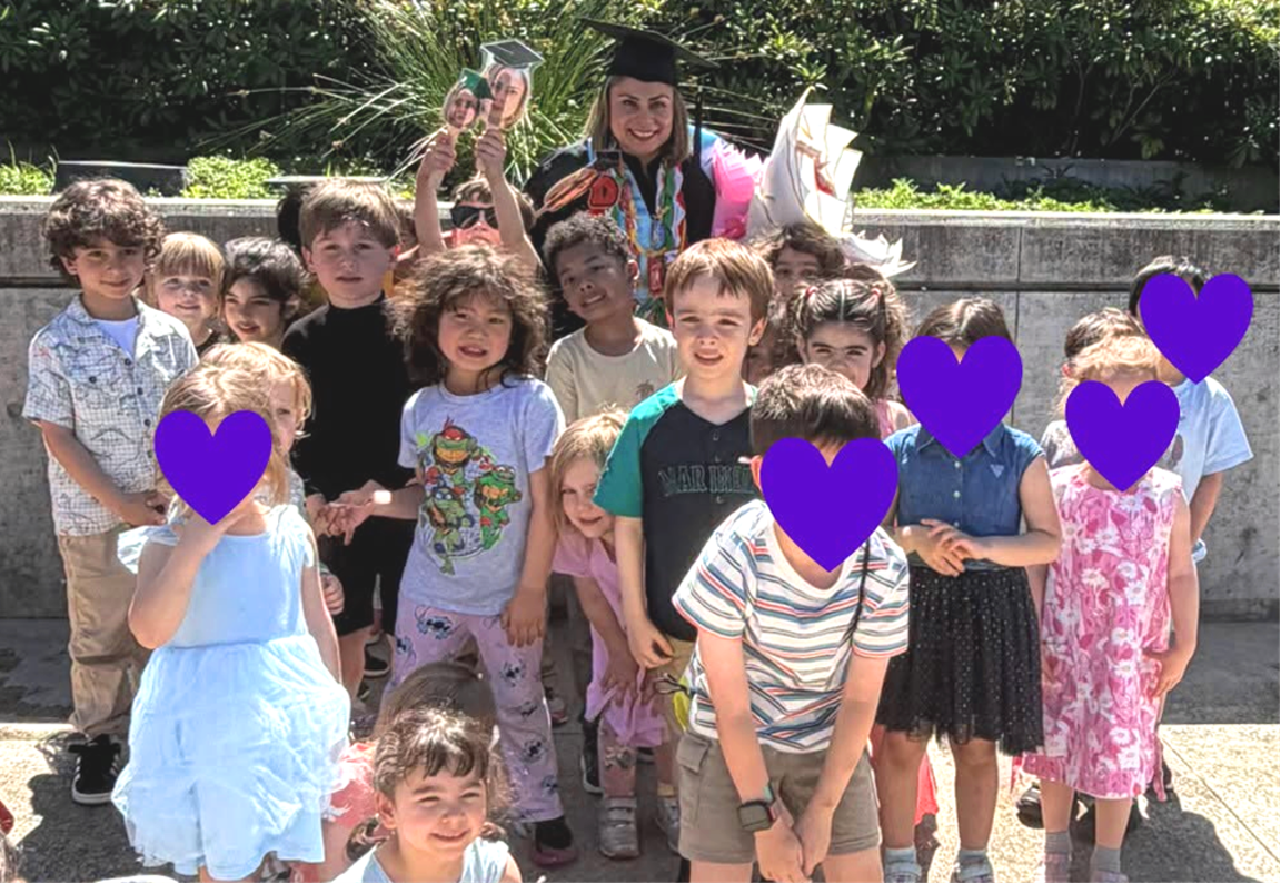 kids standing with a female wearing a graduation black cap and gown