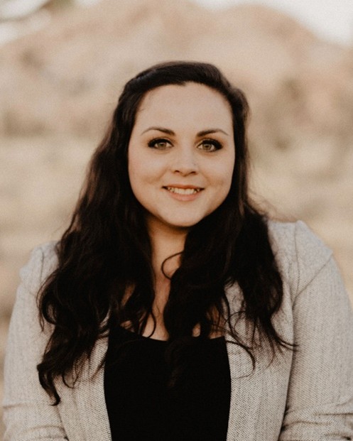 female smiling wearing a black undershirt with a beige blazer